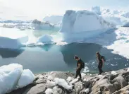  ?? Sean Gallup / Getty Images ?? Visitors walk along Greenland’s Ilulissat Icefjord during unseasonab­ly warm weather last month.