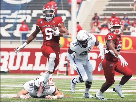  ?? Gary Kazanjian / Associated Press ?? Fresno State Jalen Cropper (5) runs past a pair of UConn defenders during the first half Saturday in Fresno, Calif.