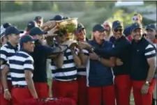  ?? THE ASSOCIATED PRESS ?? The U.S. Team celebrates with the winner’s trophy after the final round of the Presidents Cup at Liberty National Golf Club in Jersey City, N.J., Sunday.