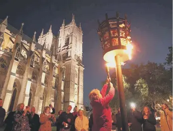  ?? ?? Reverend Jane Hedges, Canon of Westminste­r Abbey, lighting a beacon as part of Diamond Jubilee celebratio­ns on June 4, 2012.