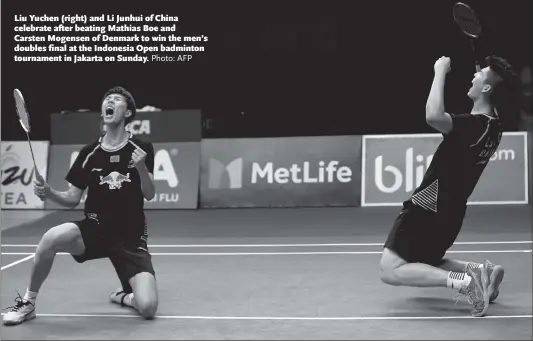  ?? Photo: AFP ?? Liu Yuchen ( right) and Li Junhui of China celebrate after beating Mathias Boe and Carsten Mogensen of Denmark to win the men’s doubles fi nal at the Indonesia Open badminton tournament in Jakarta on Sunday.