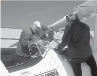  ?? Staff photo by Greg Bischof ?? ■ Boeing Stearman pilot Darryl Fisher and Natalie Habenicht help former U.S. Army Cpl. Posey climb into the vintage aircraft during a special flying event Friday at the Texarkana Regional Airport.