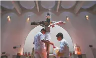  ?? AFP, vía El País. ?? Dos jóvenes preparan la cruz de la catedral de Managua (Nicaragua) para los festejos de Semana Santa, en abril. /