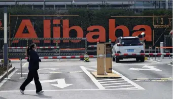  ?? GETTY IMAGES FILE ?? OPENING THE WALLET: A woman jogs in front of Alibaba headquarte­rs in Hangzhou, southwest of Shanghai, China. Chinese regulators hit e-commerce giant Alibaba with a massive $2.8 billion fine over practices deemed to be an abuse of the company's dominant market position, state-run media reported on Saturday.