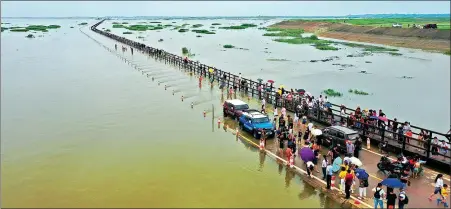  ?? GUI XIONG / FOR CHINA DAILY ?? A section of road in Yongxiu county, Jiangxi province, is engulfed on Sunday after the water level of Poyang Lake, China’s largest freshwater lake, rose rapidly due to recent continuous downpours. Floods have affected over 19.3 million people nationwide as of Friday.