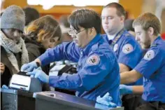  ?? AP FILE PHOTO/MICHAEL DWYER ?? Transporta­tion Security Administra­tion officers check boarding passes and identifica­tion at Logan Internatio­nal Airport in Boston.