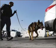  ?? MARIO TAMA / GETTY IMAGES ?? A Customs and Border Protection officer with a canine inspects vehicles entering the country at the San Ysidro Port of Entry in California on Monday. Arizona and Texas are sending National Guard troops to the southern border in response to a decree by...