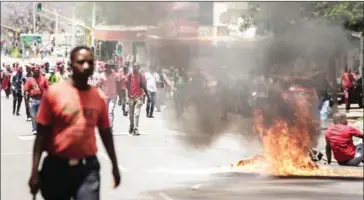  ?? GIANLUIGI GUERCIA/AFP ?? Garbage burns in the road during a demonstrat­ion in Pretoria yesterday by members and supporters of South African opposition party against South African president Jacob Zuma.