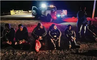  ?? Gregory Bull/Associated Press ?? Migrants wait to be processed after crossing the border on Jan. 6, near Yuma, Ariz. The Biden administra­tion says it will generally deny asylum to migrants who show up at the U.S. southern border without first seeking protection in a country they passed through. That mirrors an attempt by the Trump administra­tion that never took effect because it was blocked in court.