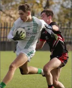  ??  ?? Midfielder Jude Bates driving past Ben Smullen of St. Mary’s.