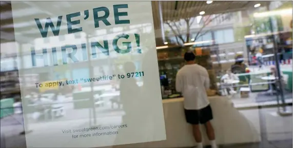  ?? THE ASSOCIATED PRESS ?? A sign announcing they are hiring hangs in the window of a restaurant in the Greenwich Village neighborho­od of Manhattan. Some restaurant­s in New York City are starting to hire employees now that they can increase their indoor dining to 75% of capacity starting Friday.