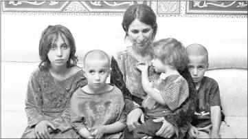  ?? — AFP photo ?? Photo shows a woman and four children among the six released of 27 Druze hostages held by the Islamic State (IS) group in a prisoner swap and ransom, upon their arrival at a government-controlled building in Syria’s southern city of Sweida.