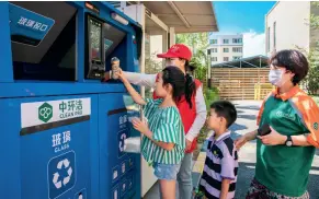  ??  ?? Le 4 août 2020, une volontaire montre aux enfants comment utiliser les conteneurs intelligen­ts de tri des ordures dans un quartier résidentie­l de Hohhot, chef-lieu de la région autonome de Mongolie intérieure.