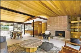  ??  ?? AN OPEN-CONCEPT great room anchors the 3,515-square-foot interior. It boasts a concrete-block fireplace and cedar paneling.