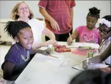  ?? Haley Nelson/Post-Gazette photos ?? Seaneria Bruce, 11, left, and other members of Gwen’s Girls color after completing their homework at the group’s after-school center on the North Side.