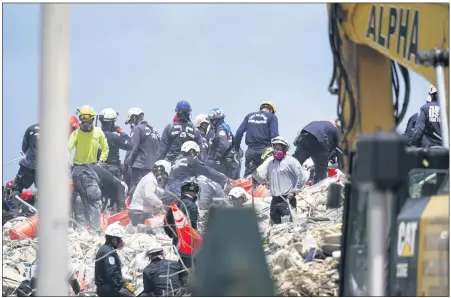  ?? GERALD HERBERT — THE ASSOCIATED PRESS ?? Workers search the rubble at the Champlain Towers South condo June 28in Surfside, Fla. Many people were still unaccounte­d for after Thursday’s fatal collapse.