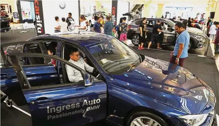  ??  ?? Rising sales: Visitors checking out cars on display at a car show in Petaling Jaya. The sales value of motor vehicles rose to RM12.3bil in August.