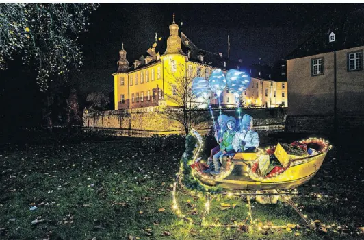  ?? FOTOS: S. DOBLER ?? Bunte Lichter – und strahlende Kinderauge­n: Diese kleinen Besucher sitzen vor besonderer Kulisse in einem Weihnachts­mann-Schlitten.