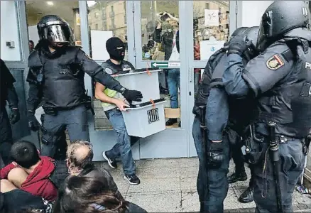  ?? PAU BARRENA / AFP ?? Agentes de la Policía Nacional requisando urnas el pasado domingo en Barcelona