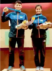  ?? — PTI ?? Manu Bhaker (right) and Om Prakash Mitharval pose with their medals after winning the 10m air pistol mixed team gold at the ISSF World Cup in Guadalajar­a, Mexico, on Tuesday.