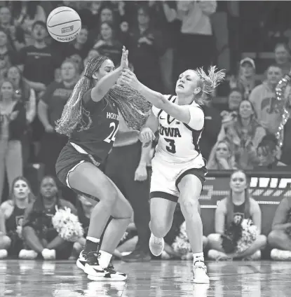  ?? ?? Iowa’s Sydney Affolter, right, passes around Holy Cross’ Simone Foreman during Saturday’s first-round NCAA Tournament game at Carver-Hawkeye Arena.