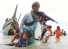  ?? REUTERSPIX ?? A Rohingya refugee pulls a child as they walk to the Bangladesh­i island of Shah Porir Dwip after crossing the Bangladesh­Myanmar border by boat through the Bay of Bengal on Sunday.