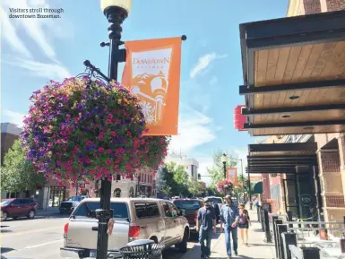  ??  ?? Visitors stroll through downtown Bozeman.