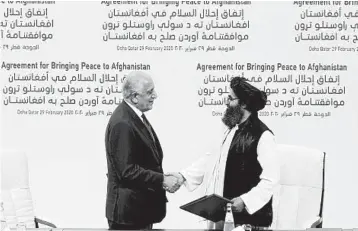  ?? HUSSEIN SAYED/AP ?? U.S. peace envoy Zalmay Khalilzad, left, and Taliban Mullah Abdul Ghani Baradar after signing a peace deal Feb. 29.