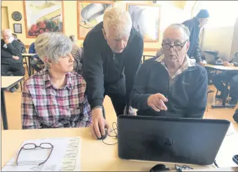  ?? FRAM DINSHAW/THE NEWS ?? Edith Avery, left, has her tax return completed by volunteer Ken Snell, right, as Allan Murray has a look at the work at the tax clinic inside New Glasgow Atlantic Superstore on Tuesday.