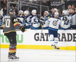  ?? The Associated Press ?? Winnipeg Jets centre Mark Scheifele is congratula­ted by teammates after his goal against the Vegas Golden Knights during the second period of Game 3 on Wednesday in Las Vegas. Scheifele scored both goals for Winnipeg in a 4-2 loss.