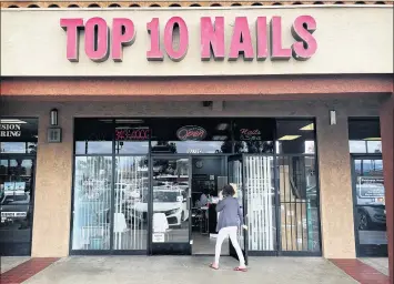  ?? WATCHARA PHOMICINDA — STAFF PHOTOGRAPH­ER ?? A customer walks into Top 10 Nails in Riverside on Thursday. The owner of the nail salon received an anonymous hate letter demanding that they, “go back to their country.”