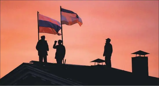  ?? Dan Kitwood Getty Images ?? FLAGS of Russia and Crimea were installed on the roof of a building in the Crimean portion of Ukraine, after Russia sent in troops and annexed Crimea in 2014.