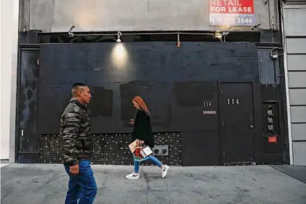  ?? Lea Suzuki/The Chronicle ?? Pedestrian­s pass the boarded-up Hotel Union Square on Powell Street. Its owners filed a $5.6 million claim against the city.