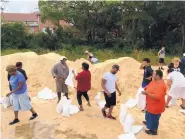  ?? JEFF AMY/ASSOCIATED PRESS ?? Residents fill sandbags in preparatio­n for Hurricane Nate in Moss Point, Miss., on Saturday. The storm surge threatens many low-lying neighborho­ods in city, which was heavily flooded during 2005’s Hurricane Katrina.