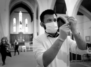  ?? AP ?? Pharmacist Rajan Shah prepares a syringe of the AstraZenec­a vaccine at St John’s Church, in Ealing, London, yesterday.