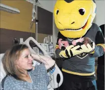  ??  ?? Golden Knights mascot Chance delivers Vegas Born onesies to newborn babies