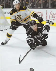  ?? AP PHOTO ?? ALL OVER ’EM: Kings center Trevor Lewis goes down under the pressure of defenseman Colin Miller during Thursday night’s Bruins victory in Los Angeles.
