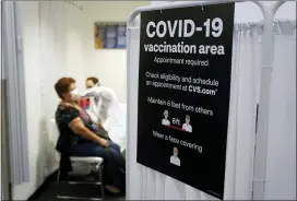  ?? ASSOCIATED PRESS FILE PHOTO ?? A patient receives a shot of the Moderna Covid-19vaccine next to a guidelines sign at a CVS Pharmacy branch in Los Angeles.