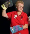  ??  ?? Heartland Lions president Jeanette Izod showing off the knitwear for dementia patients.