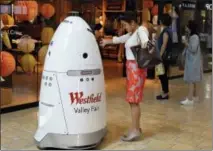  ?? THE ASSOCIATED PRESS ?? Sophie Li, of Cupertino, Calif., offers to dance with a K5 robot made by Knightscop­e Inc., at Westfield Valley Fair shopping center in San Jose, Calif.