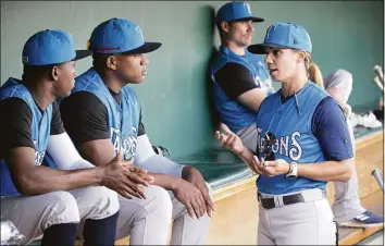  ?? Phelan M. Ebenhack / Associated Press ?? Tampa Tarpons manager Rachel Balkovec, right, chats in the dugout with pitchers Juan Carela, left, and Yon Castro while making her debut as a minor league manager on Friday.