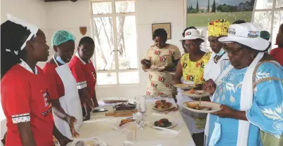  ?? ?? Plumtree High School Food and Nutrition team leader Wisisani Nleya explains their traditiona­l dishes to Mangwe District Developmen­t Coordinato­r, Rorisang Makhurane (right) as ZANU PF Women’s League Matabelela­nd South members taste the dishes prepared at Plumtree High School in Plumtree yesterday.