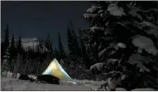  ?? SHAUN DAVIES — — NOLS — NATIONAL OUTDOOR LEADERSHIP SCHOOL VIA AP ?? A tent glows in the light of a headlamp as students on a Spring Semester in the Rockies get ready to sleep after a long day of ski touring in Wyoming’s Absaroka Mountains.