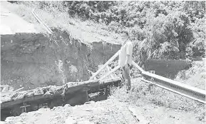  ??  ?? TIDAK DAPAT DILALUI: Jambatan ke Kampung Nampasan yang runtuh dipercayai akibat hakisan tanah.