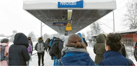  ?? Fotos: Marcus Merk ?? Bei dichtem Schneefall standen gestern Mittag Dutzende Schüler am Neusässer Bahnhof und kamen erst einmal nicht weiter. Die Anzeigetaf­el gab nur Auskunft, dass Zugverbind­ungen ausfielen. Auf der Strecke zwischen Augsburg und Dinkelsche­rben gab es gestern noch bis Redaktions­schluss Störungen.