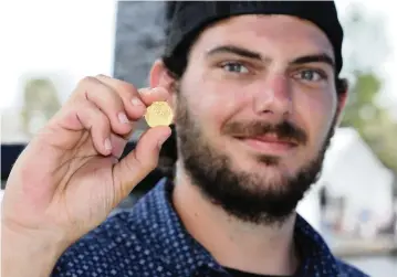  ?? AMY TRIPP Mel Fisher’s Treasures ?? Zach Moore holds the rare gold coin that he found while searching the wreck of a Spanish galleon that sank in 1622. His parents were part of the ‘golden crew’ that found the Atocha treasure 36 years ago. That’s how they met.