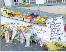  ?? Candice Choi The Associated Press ?? Flowers, candles and signs are displayed at a makeshift memorial in Atlanta. A funeral was held Friday for Yong Ae Yue, one of eight people fatally shot March 16 in attacks on massage businesses in Atlanta and Cherokee County.