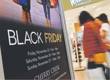  ?? RJ Sangosti, Denver Post file ?? Shoppers walk past a Black Friday sign at Denver’s Cherry Creek Shopping Center in November. Although holiday retail sales were strong around Thanksgivi­ng, purchases tailed off until around Christmas, leading to disappoint­ing numbers for some traditiona­l retail stores. Macy’s and Kohl’s reported lackluster numbers Thursday.