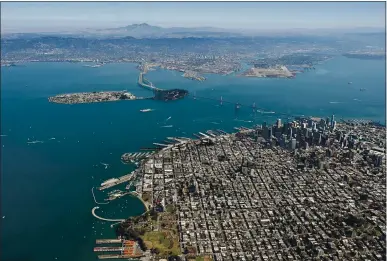  ?? JOSH EDELSON — AFP VIA GETTY IMAGES ?? The Bay Bridge is seen from above in San Francisco in 2015. More mud and dirt will be required to build up the height of marshes and mudflats that ring the bay’s shoreline to combat rising sea levels.