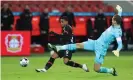  ??  ?? Leon Bailey scores his second goal for Leverkusen against Hoffenheim despite the efforts of Oliver Baumann. Photograph: Lars Baron/Getty Images